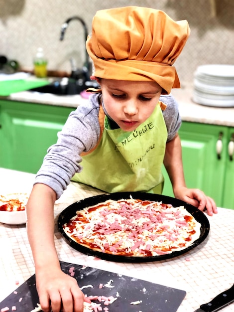 Photo boy preparing pizza at home