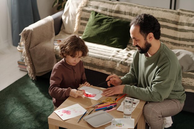 Boy preparing postcard for mother day