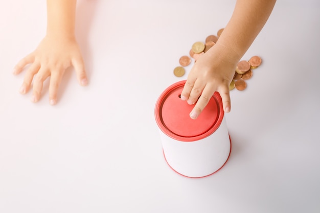 Boy putting money into a coin bank