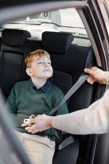 車の中で安全ベルトを着用している少年