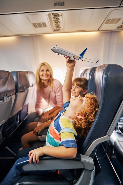 Boy raising a toy aircraft over his head