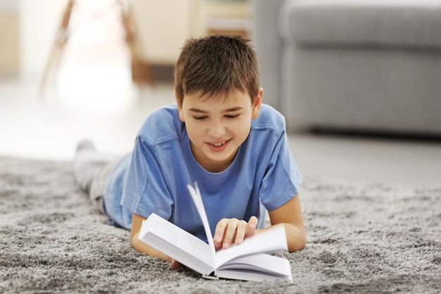 Boy reading book on a floor at home