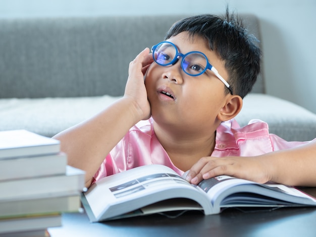 Photo boy reading a book at home. education concept