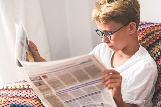 Foto ragazzo che legge il giornale a casa