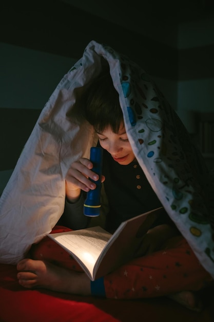 Boy reading with a flashlight