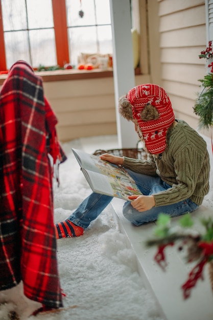 Мальчик читает книгу на Рождество