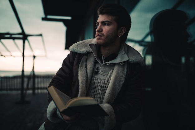 Boy reads a book and looks away