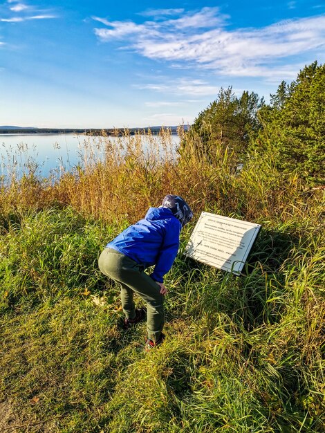 A boy reads a sign on the White Sea coast on a sunny day Karelia Russia 2021