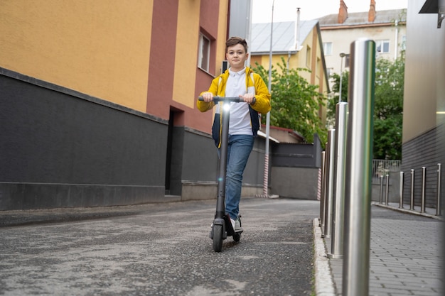 Boy rides on electric scooter down the city street