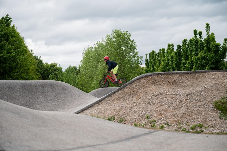 Photo 公園の外のポンプトラックで自転車に乗る少年