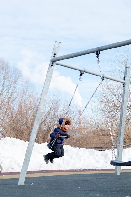 Boy riding a swing in winter