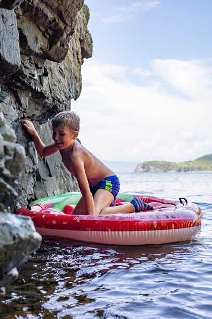 Photo boy on rock at sea shore