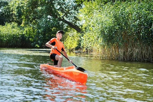 The boy rowing in a canoe on the river