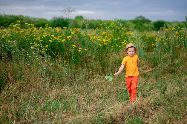 boy running across the field in summer