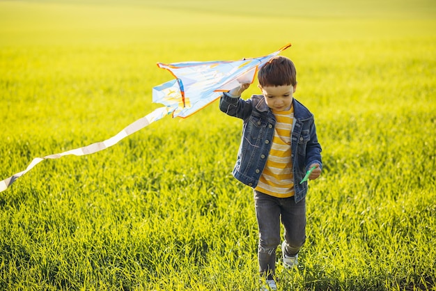 Boy running in the field with kite