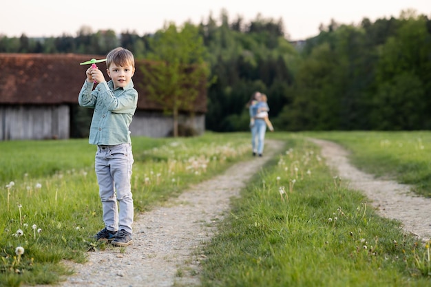 A boy on a rural road launches a toy helicopter