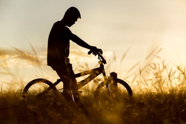  boy sat down on a bicycle in the area of strong sunlight.