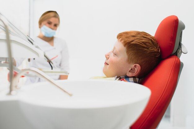 Foto ragazzo soddisfatto del servizio nello studio dentistico. concetto di trattamento dentale pediatrico