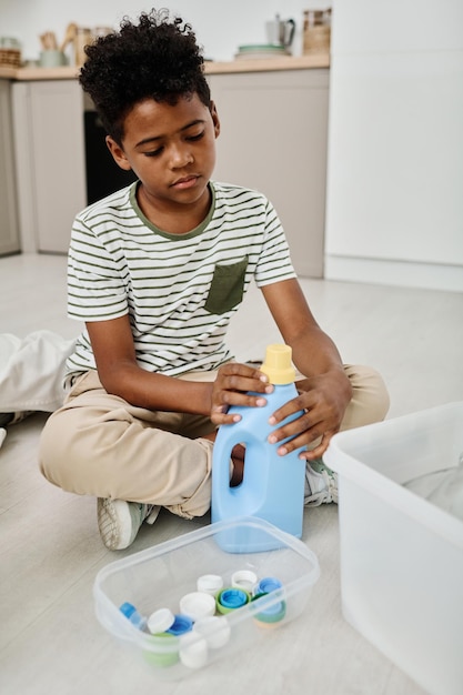 Boy separating lids from bottles