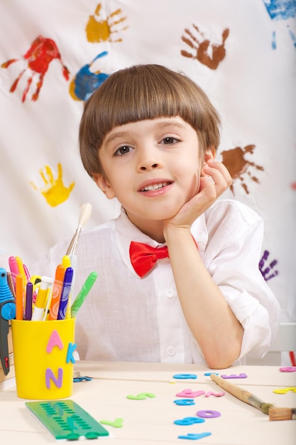 Boy of seven years old dressed in a white shirt with red bow. Closeup