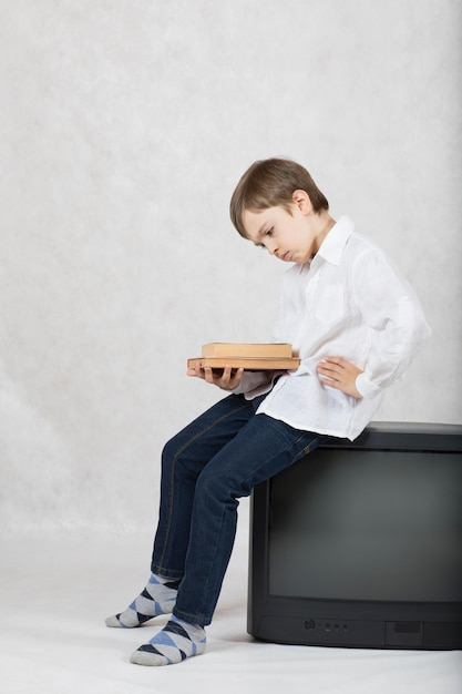 Boy of seven years old and an old TV. Free space for a text.