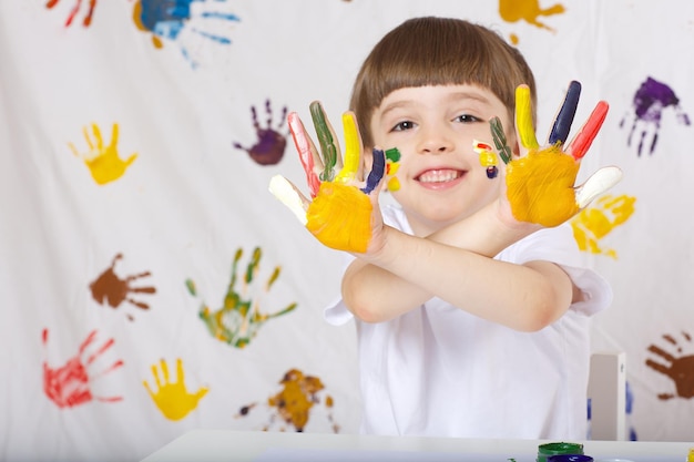 Boy of seven years old with painted palms. Closeup