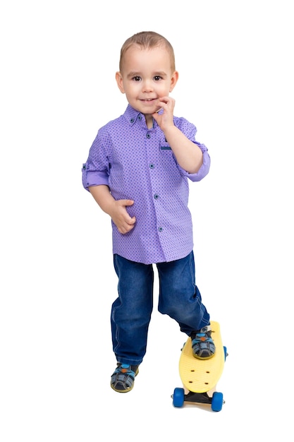 A boy in a shirt and jeans stands on a skateboard. Isolated