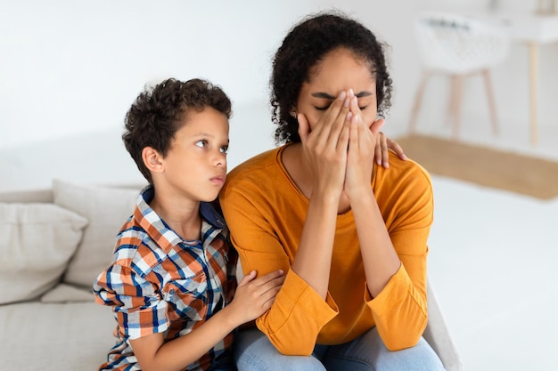 Photo boy showing concern and offering support to upset mommy indoor