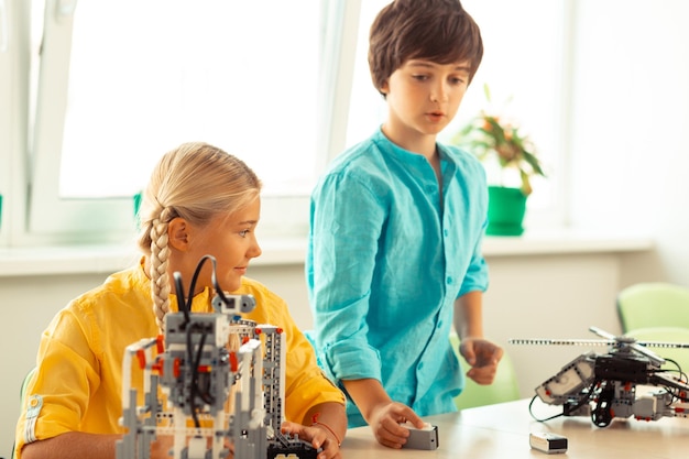 boy showing his classmate his school project