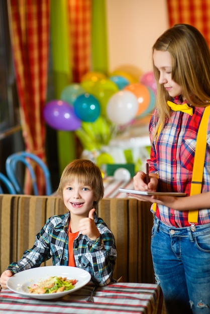 Boy showing thumbs up in cafe