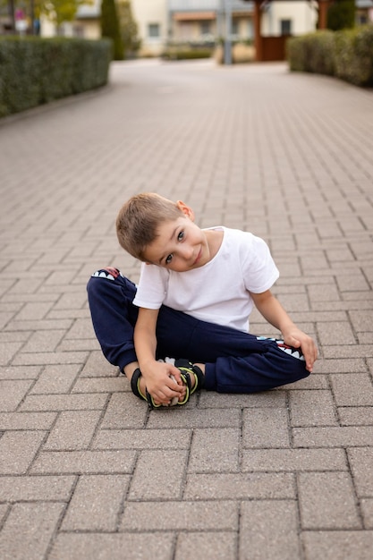 少年は地面に座って 幸せな子供時代を過ごし 休日に歩いています