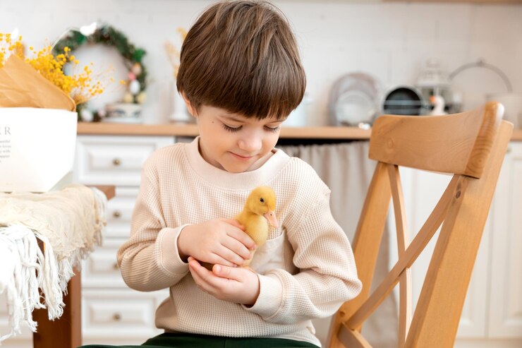 Photo a boy sits at kitchen of rustic style and hugs little yellow duckling