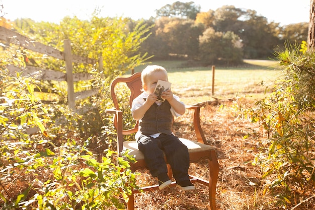 Photo boy sitting on chair at park