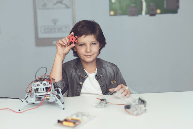 Boy Sitting at Desk and Constructing Robot at Home