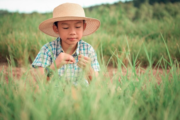 昼間に草原に座っている少年