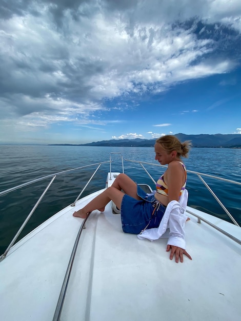写真 空の向こうの海でボートに座っている少年