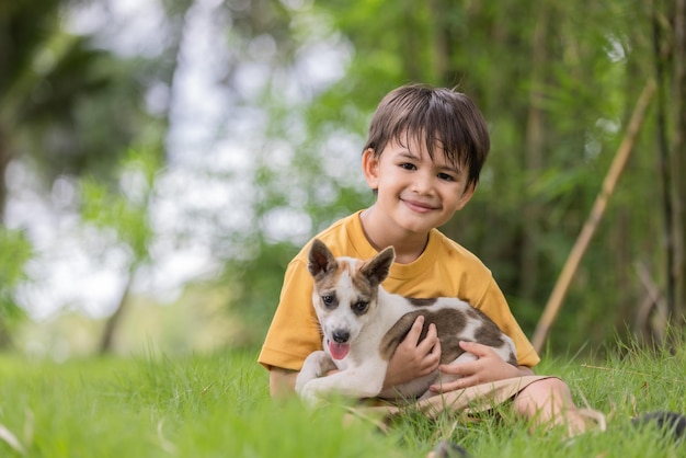 Boy sitting at park with dog