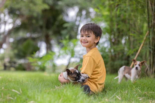 Boy sitting at park with dogs