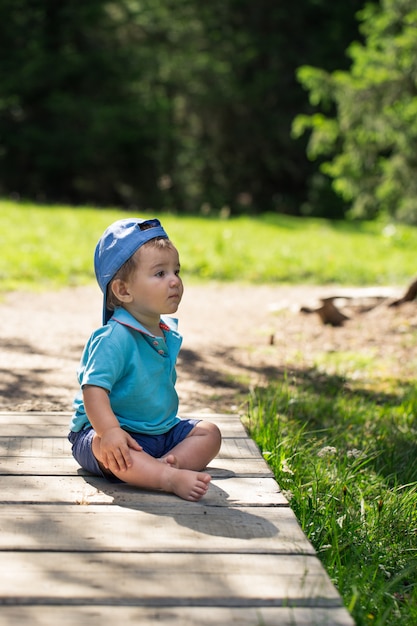 Boy sitting on a path in nature