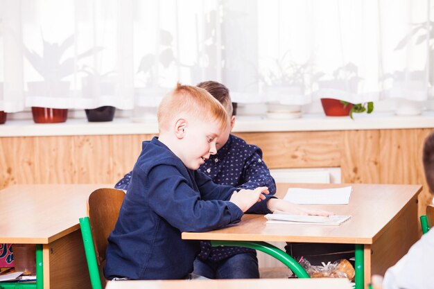 Photo boy sitting on table at home