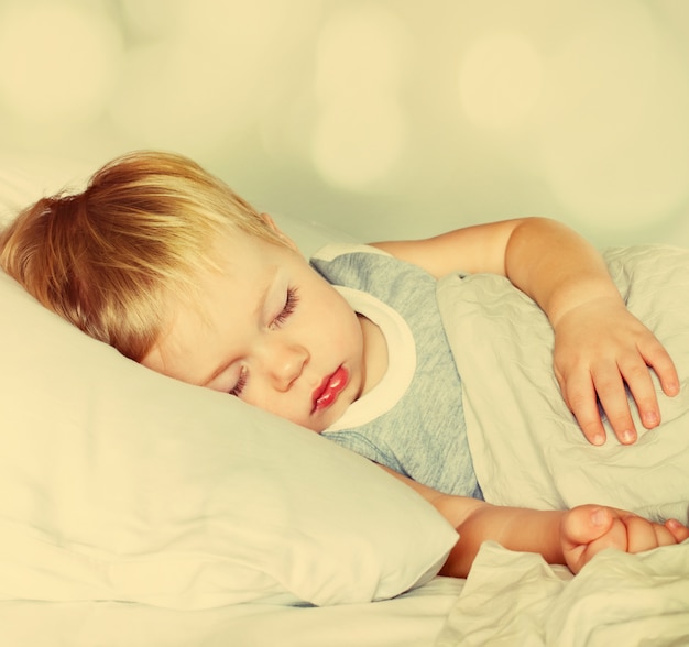 Boy Sleeping on a Bed. Toned