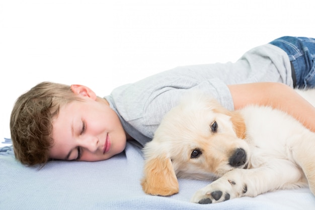 毛布に犬で眠っている男の子