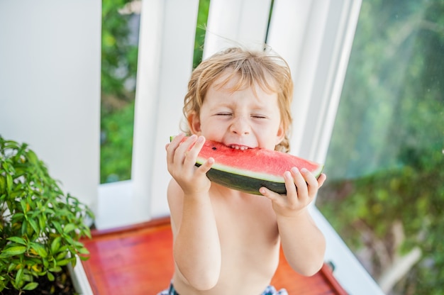 笑顔でスイカを食べる少年