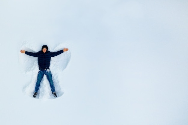 Photo the boy on a snow angel shows copy space