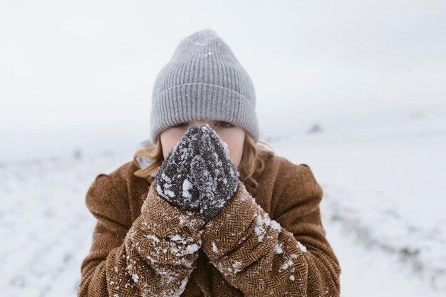 雪の中で手を温める男の子