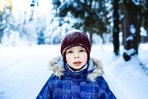 boy in snowy forest winter day  beautiful nature looking at camera