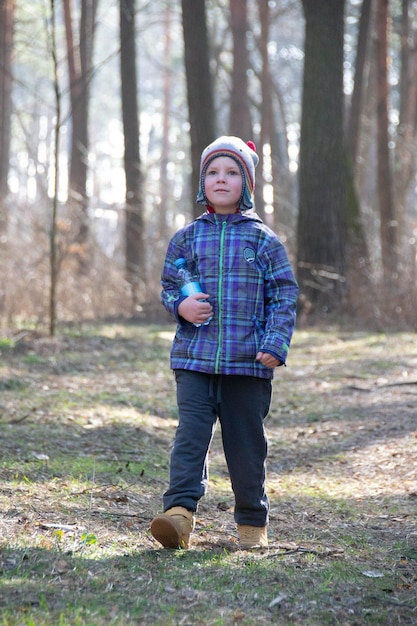 Boy spends happy time outdoors in forest enjoying autumn nature