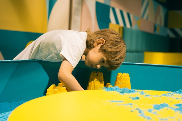 Boy spends time in children's learning game center . Development of fine motor skills. Modern educational games. Creativity and self-realization. Relieving stress and tension.