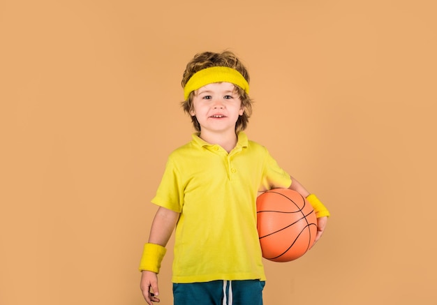 スポーツウェアの少年はボールバスケットボール選手を保持します少年はスポーツゲームを楽しむかわいい少年はバスケットボールボールを保持します