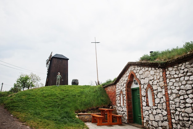 Boy stand near old wooden windmill